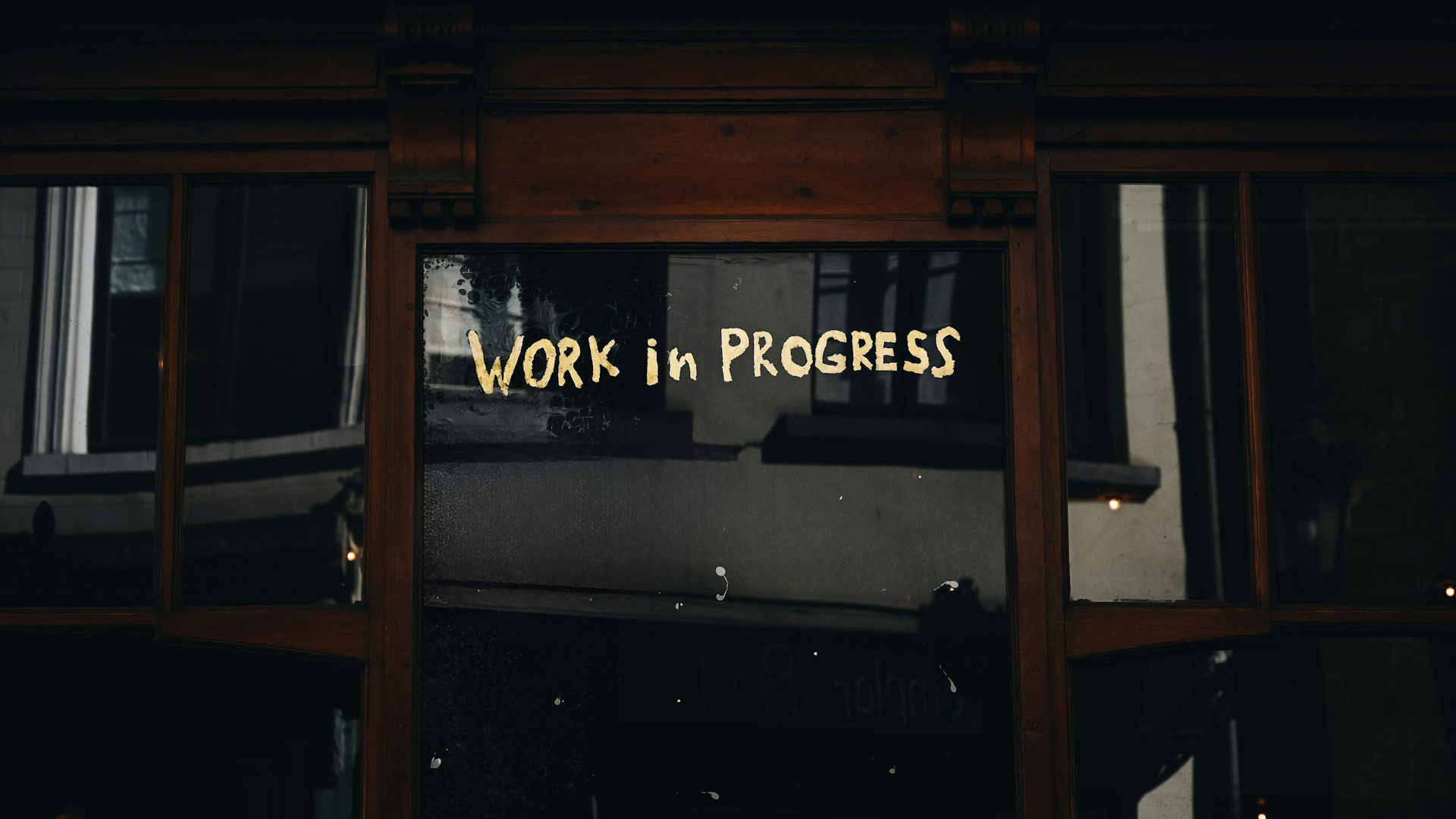 “Work in progress" is written on a glass door.