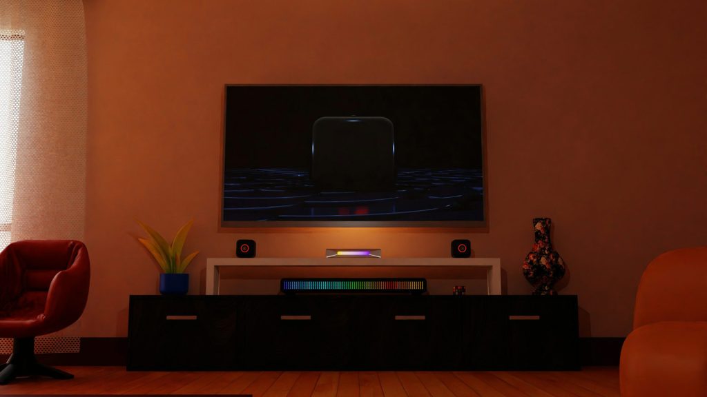 A wall-mounted TV hangs over an entertainment console with speakers and drawers.