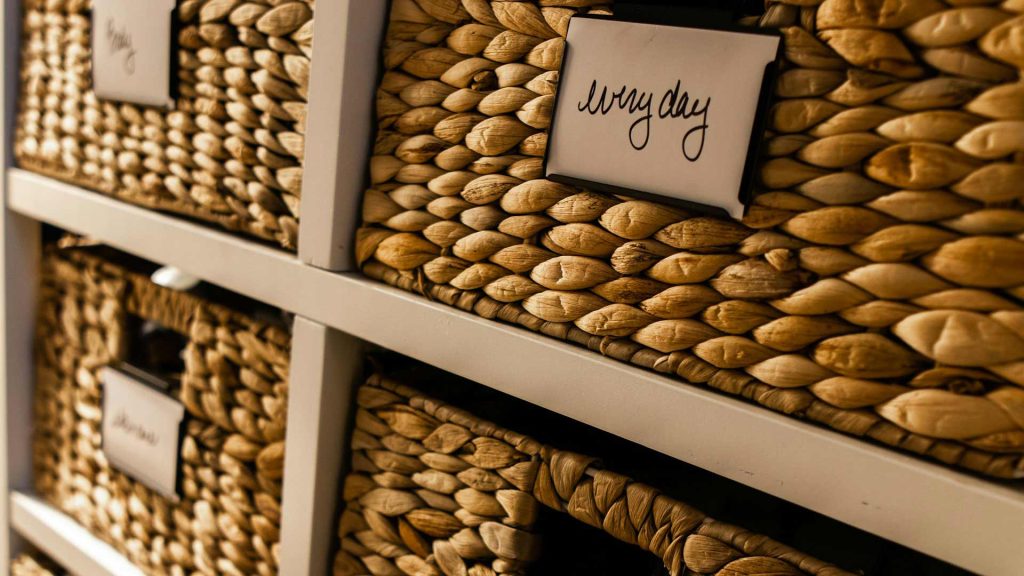 Four labeled baskets on a shelf.