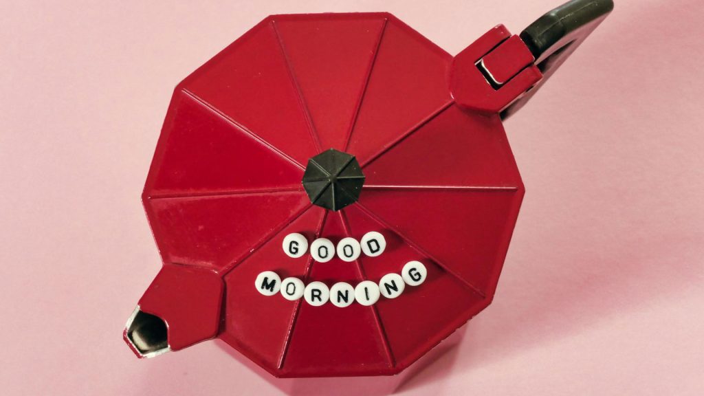 A red moka pot with white beads on it that read "Good Morning"